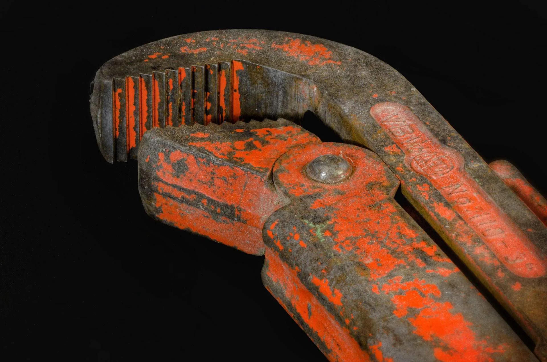 Fontanero profesional usando llave para apretar conexión de tubería en Santiago de Compostela